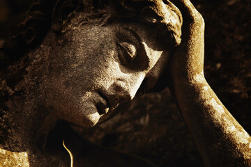 Ancient statue of sad angel as symbol of pain, death and end of life.