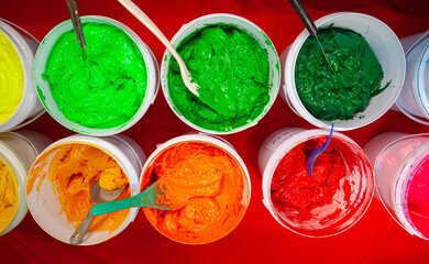 Top view, colorful fabric printing inks in white buckets..Stirring the ink for multicolored tee shirt printing ..colorful of ink forprint tee shirt in tee shirt factory..colorful ink background.