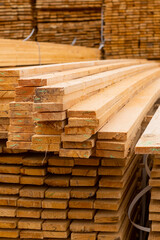 Wooden boards, lumber, industrial wood, timber. Pine wood timber stack of natural rough wooden boards on building site. Industrial timber building materials