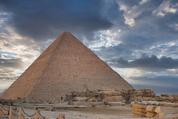 Fototapeta na wymiar The Pyramid of Cheops in Giza at sunset surrounded by clouds