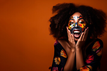 Happy and surprised woman with face painted on orange background with copy space