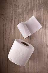 rolls of white toilet paper on a textured background
