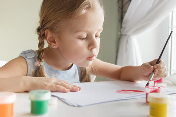 Little child draws with watercolor, concept of education in the kindergarten