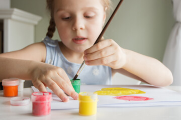 Little child draws with watercolor, concept of education in the kindergarten