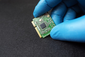 Hand holding a mini PCIe card.