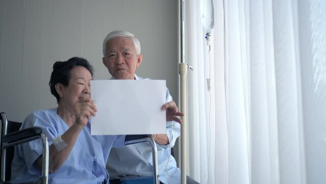 Asian senior couple happy smile holding sign copy space worry free hospital finance using insurance payment