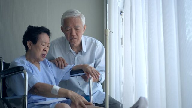 Asian senior couple supporting talking husband wife injure in hospital on wheelchair age and health promblem