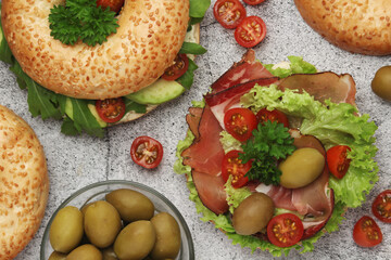 Sesame bagels with tomatoes, ham and olives	
