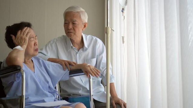 Asian senior couple supporting talking wife injure in hospital on wheelchair age and health promblem