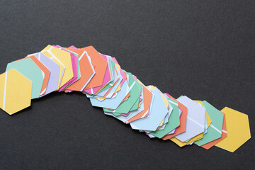 smeared pile or heap of six sided polygon or hexagon shapes cut from scrapbook paper with distinct "paint chip" coloration