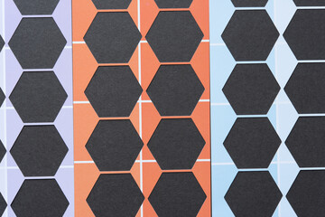 six sided polygon or hexagon shapes cut from purple, orange, and blue scrapbook paper with distinct...