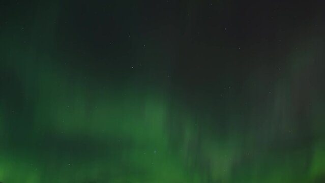 Green light of Aurora Borealis cover the night sky. Time lapse. 
