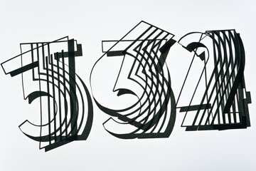 overlapping fancy type machine cut paper numbers on a light surface