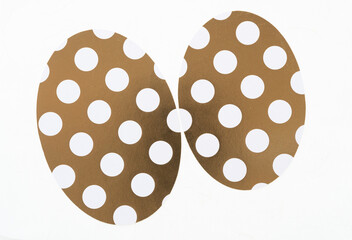 scrapbook paper machine cut shapes (mostly ovoids) on a light background - gold and white dots