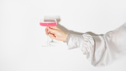Fototapeta premium panoramic banner for celebration, holiday. female hand holding a flat glass goblet with a drink
