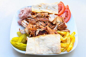 Turkish and Arabic Traditional Ramadan doner kebab with tasty tomato sauce and rice or turkish pilav in white plate on wood table background. ( Pilav ustu doner)