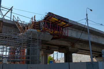 Naklejka premium Subway bridge under construction in summer city against blue sky. Modern transportation theme.