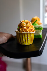 Yellow and green cupcakes arranged on black platter