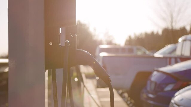 EV Charging station with electric vehicles charging, renewable energy, future transportation, charging station, sunlight. 4K 24FPS