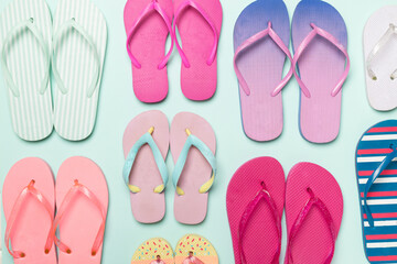 Many bright flip flops on color background, top view