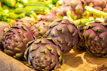 Fresh violet artichoke flower plant on the counter of the store or grocery.