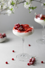 Italian panna cotta dessert with strawberry sirup and fresh strawberries on gray background.