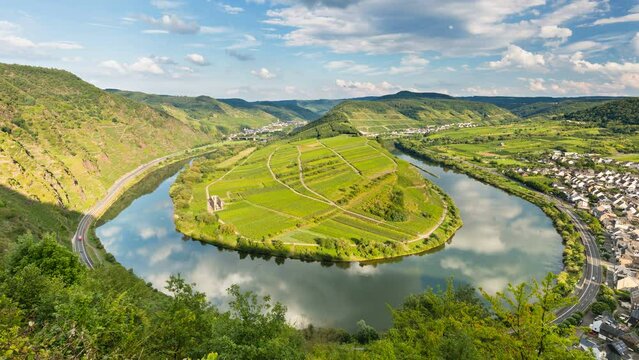 Timelapse sequence of a meander or riverbend of the Moselle River in the Eifel village of Bremm in Germany in summer. Seen from the Calmont vineyards in 4K resolution, zooming in.
