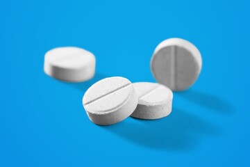 White medical pills lie on a color background.
