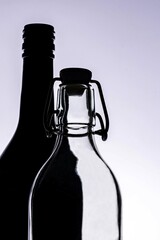 Silhouette of a black and a trasparant bottle 