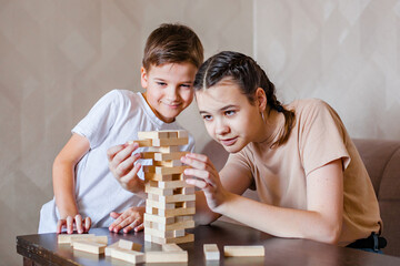 Teenage girl and boy happy brother and sister, friends playing the board game 