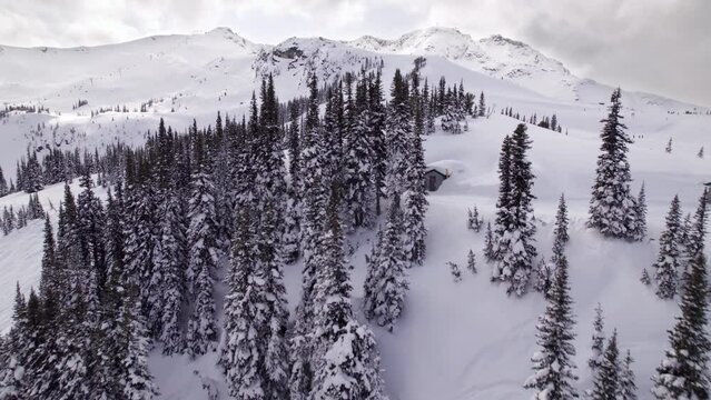 Aerial drone footage of Whistler mountain, BC, ski hill on a sunny day, chairlift, Whistler peak, ski run, skier, winter sport. 5.4K 24FPS