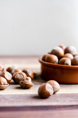 Hazelnuts in a shell and nutshells in ceramic bowl