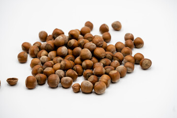 Pile of hazelnuts in a shell on white background