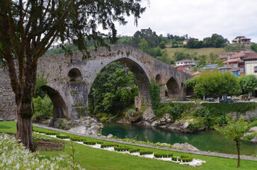 Fototapeta premium The Roman bridge of Cangas de Onis, in Asturias, Spain, below, the river Sella.