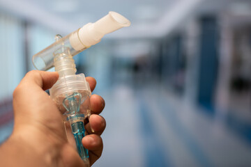 Close up of hand holding nebulizer tube respirator in the room of a hospital with copy space - obrazy, fototapety, plakaty