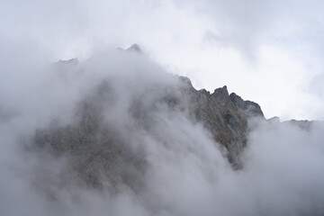 foggy clouds floating over rocky mountain peak