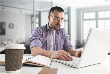 Fototapeta premium Cheerful male working on computer at home.