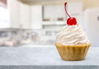 Tasty sweet Vanilla Cupcake on desk
