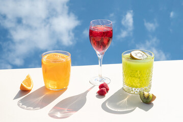 Summer drink juice cocktails. Blue sky with clouds in the background. Visual beverage party concept.