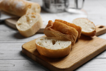 Fresh crispy ciabattas on white wooden table