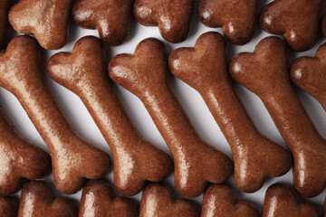 Flat lay composition with many bone shaped dog cookies on white background