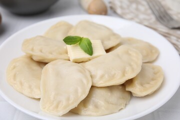 Delicious dumplings (varenyky) with tasty filling and butter on table, closeup