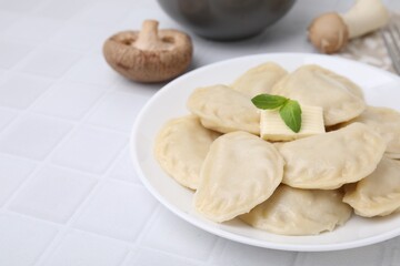 Fototapeta na wymiar Delicious dumplings (varenyky) with tasty filling and butter on white table, closeup. Space for text