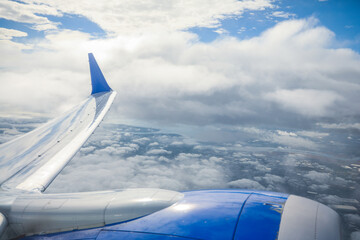 aerial view from a window seat captures the majestic airplane wing soaring through the clouds, symbolizing freedom, adventure, and travel. The view offers a sense of perspective