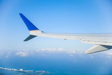 aerial view from a window seat captures the majestic airplane wing soaring through the clouds, symbolizing freedom, adventure, and travel. The view offers a sense of perspective