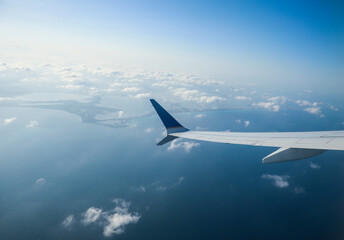 Fototapeta na wymiar aerial view from a window seat captures the majestic airplane wing soaring through the clouds, symbolizing freedom, adventure, and travel. The view offers a sense of perspective