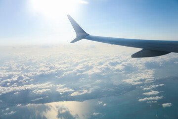 aerial view from a window seat captures the majestic airplane wing soaring through the clouds, symbolizing freedom, adventure, and travel. The view offers a sense of perspective