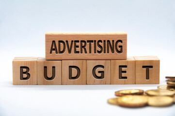 Advertising budget text engraved on wooden blocks on white background cover. Business and budgeting...