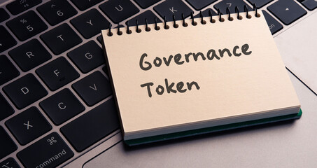 There is notebook with the word Governance Token.It is as an eye-catching image.