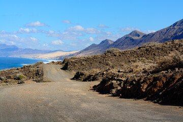 View on difficult to access golden sandy Cofete beach hidden behind mountain range on Fuerteventura, Canary islands, Spain